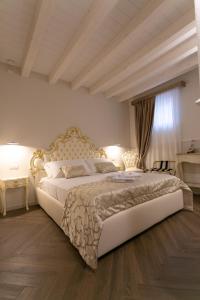 a bedroom with a large white bed with two lamps at Ca' Vittoria Apartsuite House Chioggia in Chioggia