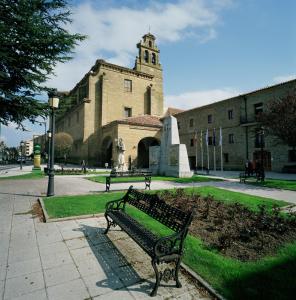 a bench in front of a building with a clock tower at Parador de Sto. Domingo Bernardo de Fresneda in Santo Domingo de la Calzada