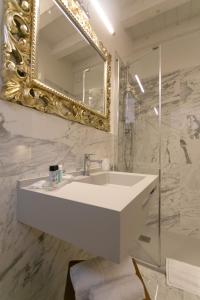 Un baño con un lavabo blanco y un espejo. en Ca' Vittoria Boutique House ApartSuite Chioggia, en Chioggia 61 fotos más