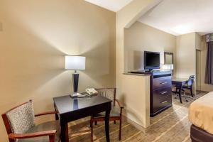 Habitación de hotel con cama y escritorio con ordenador en Quality Inn & Suites Durant, en Durant
