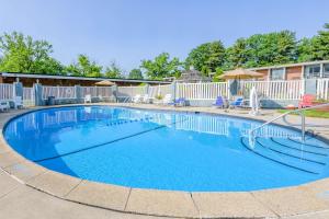a swimming pool at a resort with chairs and umbrellas at Inn at Lebanon - Hershey & Manheim area in Lebanon