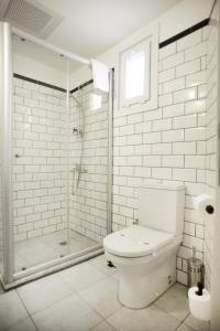 a white bathroom with a shower and a toilet at Rumours Inn in Istanbul