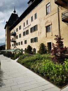 a large stone building with a courtyard in front of it at Turmapartment Lindenhof in Millstatt