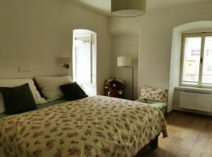 um quarto com uma cama, uma cadeira e uma janela em Turmapartment Lindenhof em Millstatt