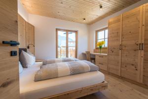a bedroom with a bed with wooden walls and a window at Eco Bnb & Apartments Bründlerhof in Marlengo +106 photos