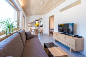 a living room with a couch and a flat screen tv at Eco Bnb & Apartments Bründlerhof in Marlengo