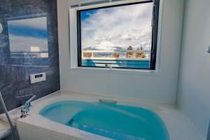 a bath tub in a bathroom with a window at villa hanasaku 富士御殿場 アウトレット in Gotemba