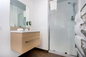 a bathroom with a sink and a mirror at Ramada Suites by Wyndham Manukau in Auckland
