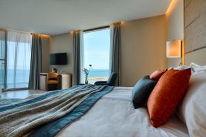 Cette chambre d'hôtel comprend un lit et offre une vue sur l'océan. dans l'établissement Wave Resort - Ultra All Inclusive, à Pomorie