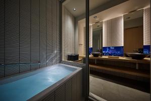 a bathroom with a large tub and two sinks at ONSEN RYOKAN YUEN SHINJUKU in Tokyo