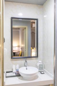 een badkamer met een wastafel en een spiegel bij Imin Hotel in Huadu