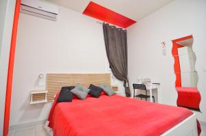 um quarto com uma cama vermelha e uma secretária em La Villa di Montagnana em Montagnana
