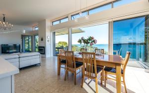 a kitchen and dining room with a table and chairs at Tui Point in Surfdale