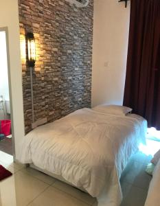 a bed in a room with a brick wall at BEDONG GOLF VILLA in Bedung