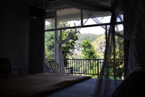 a bedroom with a bed and a window with a view at Raveena Guest House in Ella