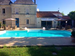 a large swimming pool in front of a house at Roulotte de Dilou Noisette in Matha