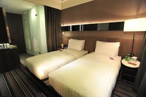 a hotel room with two beds and a table at WESTGATE Hotel in Taipei