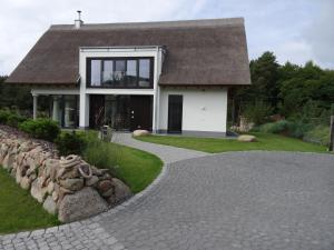 a house with a stone walkway in front of it at 5 Sterne Luxusdomizil im Dünenland in Ostseebad Karlshagen