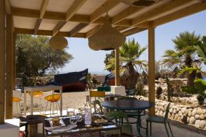 エッサウィラにあるRiad Tamayourt Ocean View & piscine chauffée à 30のビーチのパティオ(テーブル、椅子付)