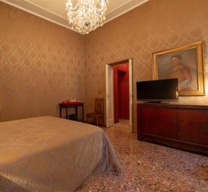a bedroom with a bed and a flat screen tv at Luxury Venetian flat for 2 near Rialto in Venice