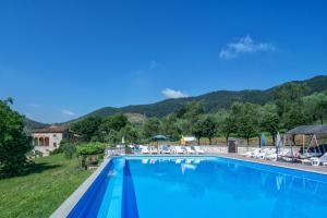 a large blue swimming pool with mountains in the background at Hotel Villa Rinascimento in Lucca