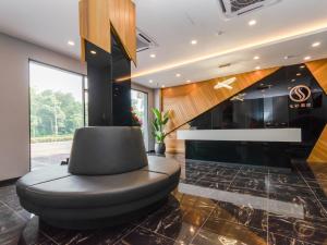 a black chair in a room with a fireplace at Solid Hotels in Johor Bahru