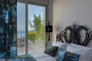 Un dormitorio con una cama y una ventana grande. en Villa K, en Skiathos 55 fotos más