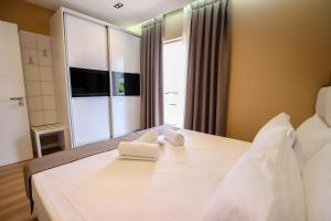1 dormitorio con 1 cama con 2 toallas en Brilant Luxury Apartment, en Gjirokastra