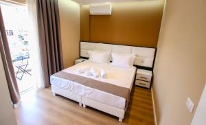 1 dormitorio con 1 cama blanca y 2 almohadas en Brilant Luxury Apartment, en Gjirokastra