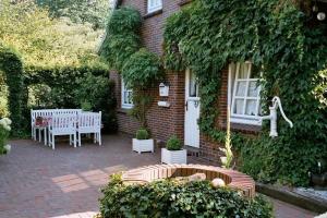 a brick house with two chairs and a bench at Ferienwohnung Landhaus im Grünen in Bad Zwischenahn