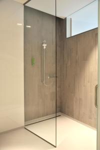 a shower with a glass door in a bathroom at Hotel Udens Duyn in Uden