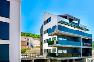 um edifício de apartamentos com varandas azuis ao lado em Stella Apartment em Cavtat