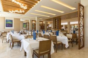 a dining room with white tables and chairs at Hipotels Barrosa Park in Chiclana de la Frontera