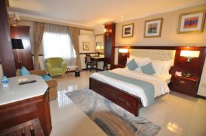 een hotelkamer met een bed en een woonkamer bij Hoa Huong Duong Hotel Saigon in Ho Chi Minh-stad