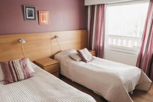 HankasalmiにあるRevontuli Resort Roomsのベッド2台と窓が備わるホテルルームです。