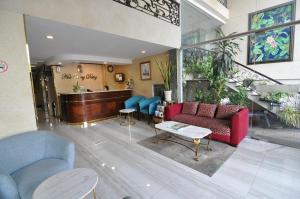 a living room with a red couch and blue chairs at Hoa Huong Duong Hotel Saigon in Ho Chi Minh City