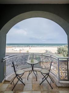 a balcony with a table and chairs and the beach at Phoenicia Boutique Hotel - Adults Only in Mamaia Nord