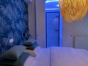 een slaapkamer met een bed met kussens en een blauwe muur bij Seashore Beach View in Koksijde