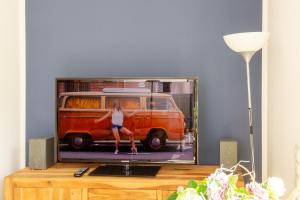 a tv screen with a picture of a woman sitting on a van at Ferienwohnung im Paradiesgarten in Deidesheim