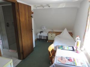 a small bedroom with a bed and a shower at Der Gasthof in Alfdorf in Alfdorf