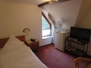 een kleine slaapkamer met een bed en een raam bij Der Gasthof in Alfdorf in Alfdorf