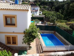 eine Villa mit einem Pool neben einem Haus in der Unterkunft Azahara in Lloret de Mar