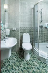 a white toilet sitting in a bathroom next to a shower at Chichikov Hotel in Kharkiv
