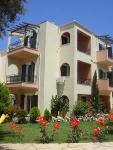 a large building with flowers in front of it at PHILIPPOS Hotel Apartments in Nikiana