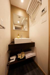 een badkamer met een wastafel en een spiegel bij Rinn Miyagawacho Grande in Kyoto