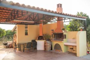 a patio with an outdoor kitchen with a pizza oven at Iro's House in Nafplio