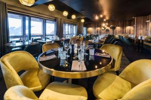a dining room with a table and yellow chairs at Fahrenheit Seven Courchevel in Courchevel