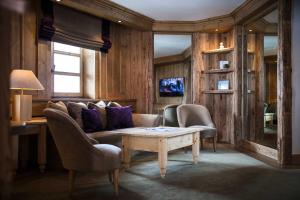 sala de estar con sofá, sillas y mesa en Hôtel Les Barmes De l'Ours, en Val dʼIsère