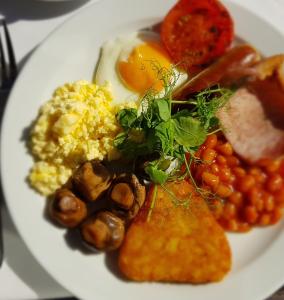 um prato de pequeno-almoço com ovos e feijão em The Riviera Hotel & Apartments - Alum Chine em Bournemouth