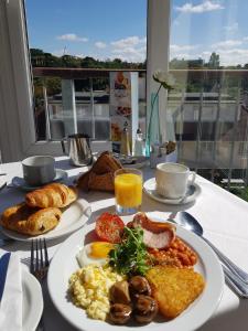 a table with plates of breakfast food on it at The Riviera Hotel & Apartments - Alum Chine in Bournemouth
